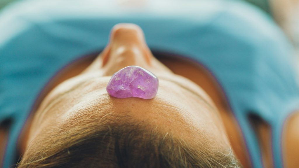 reiki stone healing in the fore head of a woman